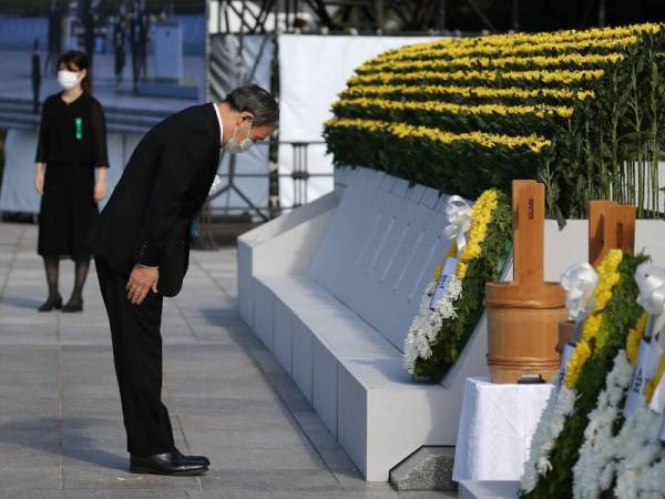 Suga (kiri) memberi penghormatan kepada korban serangan bom atom pertama di dunia itu. - Foto AFP