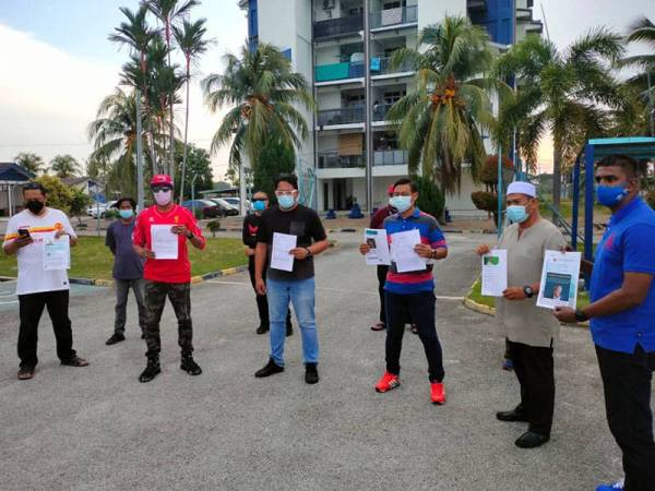 Mohd Shahrizal (tiga dari kanan) menunjukkan laporan polis yang dibuat di Balai Polis Tanjong Karang di sini pada Sabtu.