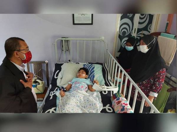 Noor Azmi (kiri) bertanya khabar Nor Bayti (kanan) ketika melawat kasih di rumahnya di Kampung Teluk Medan, Bagan Serai.