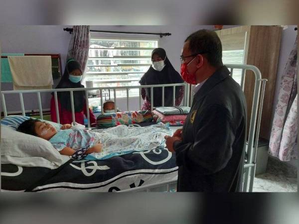 Noor Azmi (kanan) melawat Qaseh yang kini terlantar dan bergantung sepenuhnya kepada mesin oksigen.