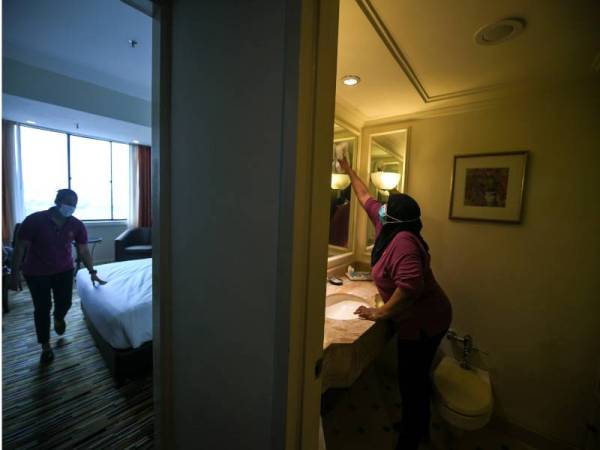 Pekerja salah sebuah hotel terkemuka di George Town melakukan kerja-kerja sanitasi di bilik hotel selepas aktiviti pelancongan dalam negeri dibenarkan oleh kerajaan bermula esok ketika tinjauan pada Isnin. - Foto Bernama 