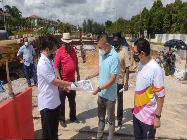 Nyuk Kiong (kiri) bersama Sze Han (dua dari kanan) di kawasan pembinaan terowong di simpang empat Lebuh Puteri, Bandar Puteri Puchong di sini pada Selasa.