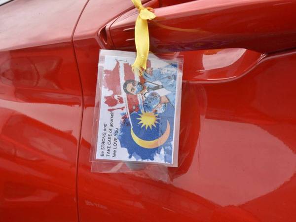 Kad beserta pen berbentuk pil bertulisan "vitamin pen" diikat pada pemegang pintu kenderaan dan cermin sisi motosikal petugas. - Foto Bernama