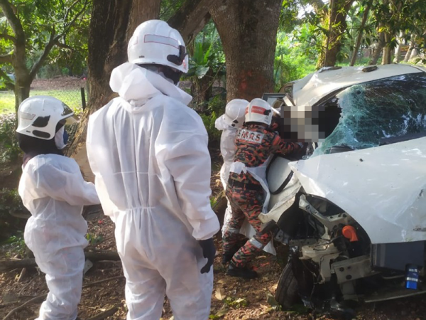 Mangsa tersepit dalam sebuah kereta sedang dikeluarkan oleh anggota bomba.
