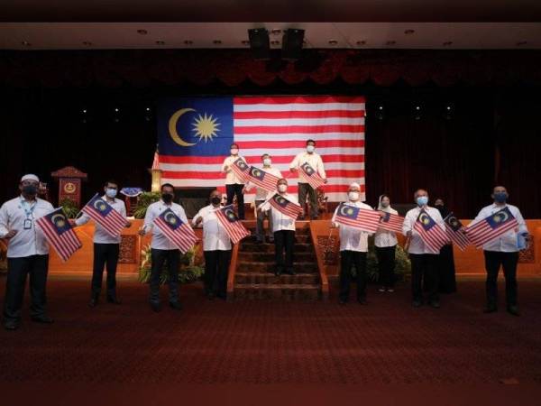 Saarani (depan, tengah) mengibarkan Jalur Gemilang bersama Ahli Majlis Mesyuarat Kerajaan negeri Perak selepas merasmikan Pelancaran Bulan Kebangsaan dan Kempen Kibar Jalur Gemilang 2021 peringkat negeri Perak di Dewan Bankuet Bangunan Perak Darul Ridzuan, di sini pada Rabu.