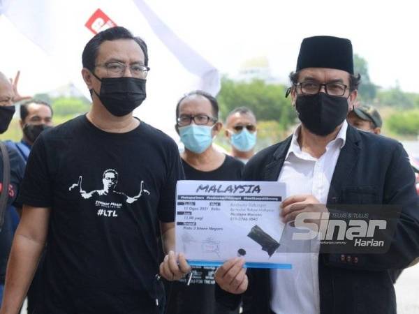 Mustafa (kanan) selepas menyerahkan memorandum rakyat Malaysia kepada wakil pihak istana di luar Pintu 3 Istana Negara pada Rabu.