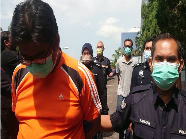 Zainal (kiri) dan Tuah Shah (tiga dari kanan) ketika dibawa keluar dari Mahkamah Sesyen Melaka, pada Khamis.