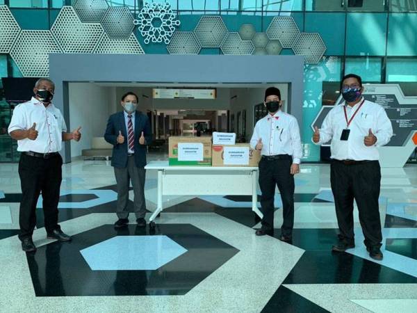 Zulkifli (dua dari kanan) mewakili KKUUiTM menyerahkan sumbangan barangan keperluan kepada petugas PPV Mega Dewan Berlian, UiTM Puncak Alam pada Khamis.