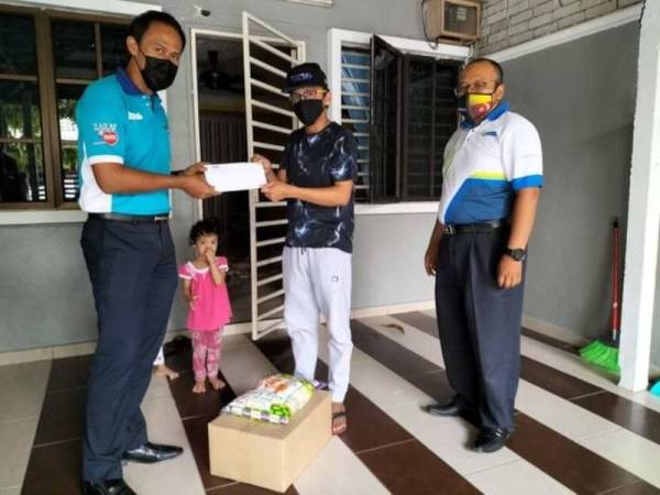 Mohd Nazri (dua dari kanan) menerima sumbangan daripada LZS selepas dilaporkan terjejas pendapatan ekoran PKP.- Foto ihsan FB LZS.