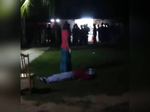 Inidvidu berbaju merah dipercayai pengawal keselamatan melihat seorang pekerja asing yang didakwa tidak sedarkan diri dalam kejadian di sebuah asrama pekerja di Pantai Puteri, Melaka pada Khamis.