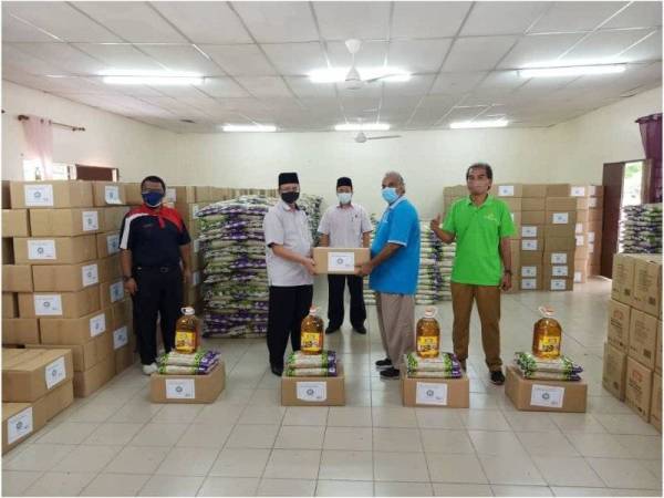 Ahmad Shahir (dua dari kiri) menyerahkan sumbangan MAIS kepada Mohamad Harun (dua dari kanan) pada Sabtu.