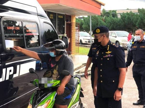 Penunggang motosikal, Wan Muhammad Abshar Wan Ahmad Shaipuddin menggunakan perkhidmatan Kaunter pandu lalu di Panji, Kota Bharu sambil dilihat Hanif Yusabra (dua dari kanan). - FOTO SINAR HARIAN