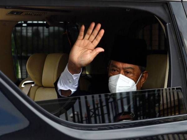 Muhyiddin melambaikan tangan kepada wartawan ketika keluar dari pekarangan Bangunan Perdana Putra tengah hari ini.