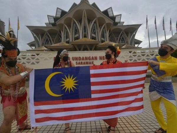 Artis pentarama Jabatan Penerangan Malaysia Sarawak (dari kiri) Vincent Paul Muling, Elliza Suezina Ekson, Olivia Parcy Bintang dan Mohd Noor Amirul Iqquan Jain bersama Jalur Gemilang selepas pelancaran sambutan Bulan Kebangsaan dan Kibar Jalur Gemilang Peringkat Negeri Sarawak pada Isnin. - Foto Bernama