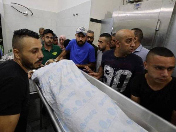 Rakan-rakan dan saudara-mara membawa jenazah Raed Abu Seif di sebuah hospital di Jenin pada Isnin. - Foto AFP