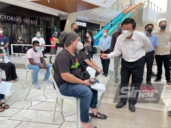 Kon Yeow bertanya sesuatu kepada orang ramai yang datang ke RiVAC untuk menerima suntikan vaksin di Gurney Paragon, Georgetown pada Selasa.