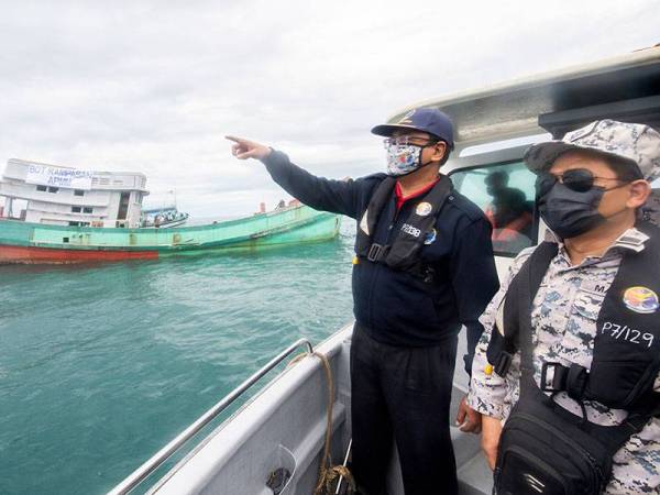 Timbalan Ketua Pengarah Pengurusan Maritim Malaysia Khairul Anwar Bachok (kiri) bersama Pengarah Maritim Negeri Kelantan Kepten Maritim Syed Nor Adli Syed Ab Rahman melihat empat buah bot nelayan asing Vietnam secara penenggelaman untuk dijadikan tukun tiruan di perairan negeri itu hari ini.