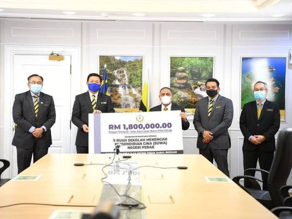 Saarani (tiga dari kanan) menyerahkan replika cek bantuan pendidikan kepada sembilan Sekolah Persendirian Cina (SUWA) bernilai RM1.8 juta.