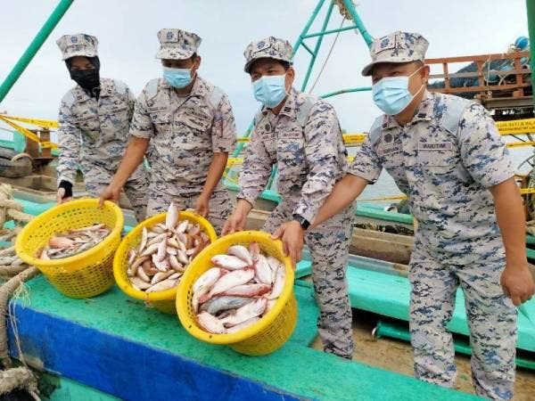 Syed Nor Adli (dua dari kanan) bersama pegawainya menunjukkan ikan yang dirampas selepas menahan kapal Vietnam dalam dua serbuan berasingan di perairan Kelantan pada Selasa.