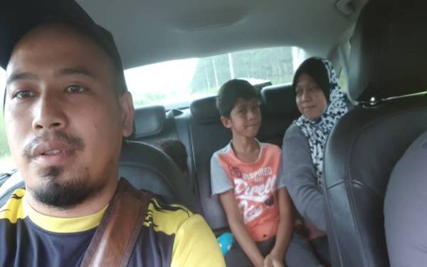 Rizduan (depan) membantu membawa keluarga tersebut ke rumah baharu mereka di Kampung Baru Padang Sanai, Kuala Nerang pada Rabu. - Foto Ihsan RIZDUAN DAUD