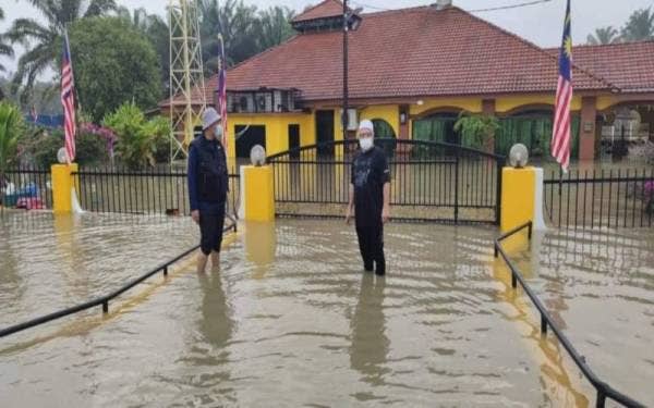 Mohd Kamaruddin (kanan) meninjau situasi banjir di sekitar kawasan Matang yang bermula sejak petang Rabu. - Foto FB Tkub Bukit Gantang
