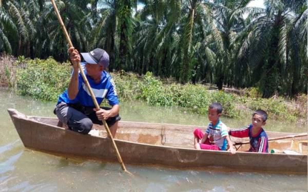 Penduduk menggunakan sampan untuk bergerak setelah kampung mereka banjir akibat ban pecah pada Jumaat. 