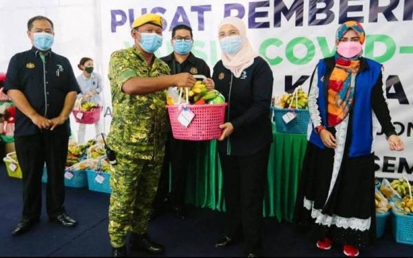 Azulita (dua dari kanan) menyerahkan sumbangan bakul makanan kepada petugas keselamatan.