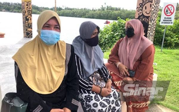 Zakiah bersama ahli keluarga lain yang menunggu khabar berita Mohd Rafi di Jeti Nelayan Pantai Sabak, Kota Bharu pada Ahad.