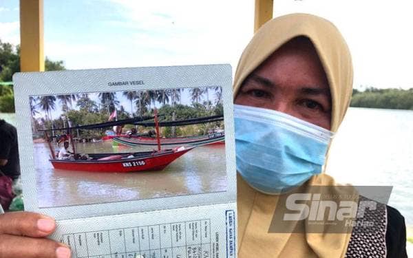 Zakiah menunjukkan gambar Mohd Rafi yang dikuatiri hilang selepas keluar mencandat sotong di Kota Bharu pada Khamis.