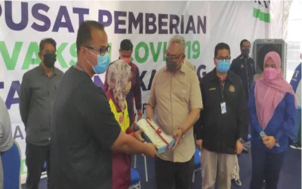 Noh (tiga dari kanan) menyampaikan sijil penghargaan kepada wakil petugas pada Majlis Penutupan PPV IPP Tanjong Karang pada Ahad.
