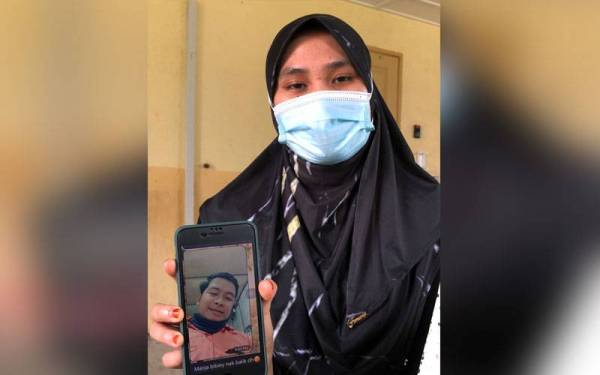 Nur Syahirah menunjukkan gambar suaminya, Mohd Nur Hisham yang maut selepas motosikal ditungganginya antara enam motosikal yang dirempuh sebuah kereta di Kilometer 4, Jalan Kampung Acheh-Sitiawan semalam. - Foto Bernama