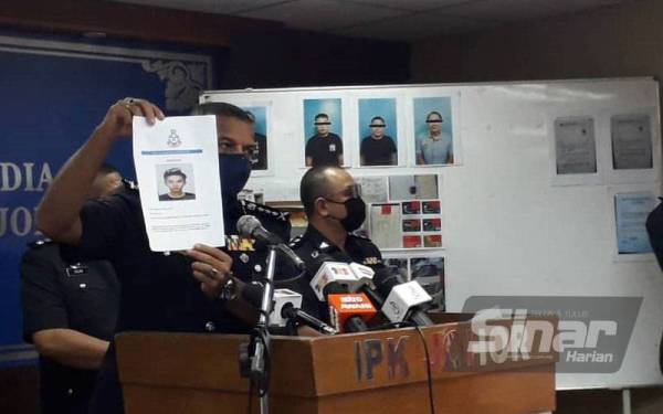 Ayob Khan menunjukkan foto Nicholas Chai Jia Han yang dicari kerana dipercayai dalang sindiket pemalsuan surat MITI serta surat pengesahan majikan pada sidang akhbar di IPK Johor, Johor Bahru, pada Isnin.