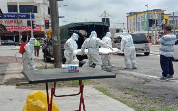 Pasukan bomba dan anggota Jabatan Kesihatan Terengganu membawa mayat lelaki yang ditemui di dalam premis rumah kedai di Pulau Kambing, Kuala Terengganu pada Isnin. Foto: Ihsan BBP Kuala Terengganu.