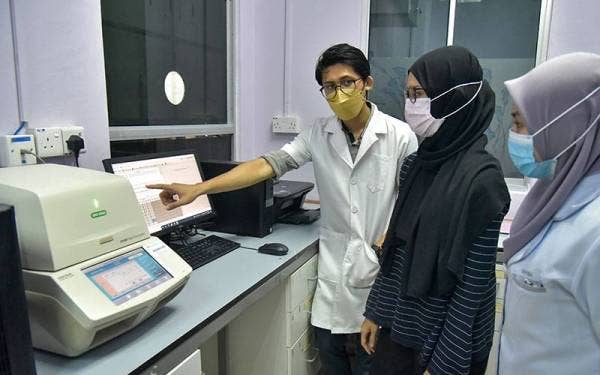 Pegawai perubatan yang bertugas menggunakan mesin pemanas termal di makmal ujian reaksi berantai polimerase (PCR) Covid-19 di Hospital Nukleus Labuan, hari ini. Foto Bernama