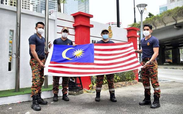 Anggota Bomba dan Penyelamat (Dari kiri) Pegawai Bomba (PB) Mohammad Shahril Sundar,23, PB Zul Atif Mohammad Derus,24, Pegawai Bomba Kanan II (PBK II) Mohamed Azimin Mohamed Zahidi,38, dan PB Muhammad Najib Mohamad Shariff,25, bersemangat memegang Jalur Gemilang yang akan digantung di hadapan Balai Bomba Dan Penyelamat Jalan Tun Razak menjelang Hari Kebangsaan 2021 hujung bulan ini.