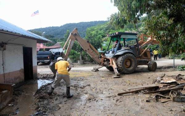 Sebahagian sukarelawan membersih rumah penduduk yang dipenuhi dengan lumpur akibat fenomena kepala air dari Gunung Jerai yang melanda Kampung Teloi Bukit. - Foto Bernama