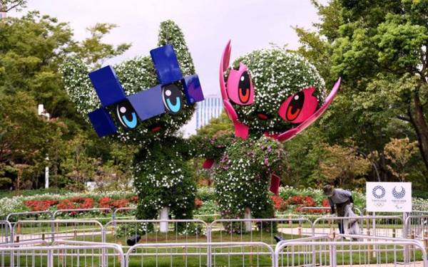 Pekerja membersihkan kawasan sekitar maskot Paralimpik Tokyo 2020, Miraitowa (kiri) dan Someity menjelang pembukaan temasya pada Selasa malam. - Foto Bernama