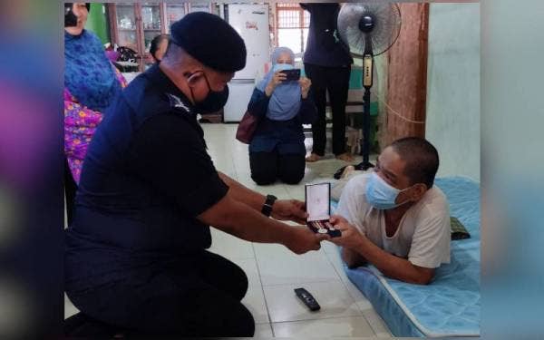 Kamarul Zaman (kiri) hadir menyampaikan sumbangan, sijil penghargaan dan Pingat Jasa Pahlawan Negara kepada pesara polis, Yahya Samat (kanan) di Taman Jelutong, Kuala Nerang pada Rabu.