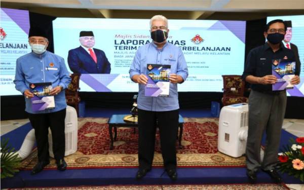 Tengku Mohamad Rizam (tengah), Zulkifle (kanan) dan Mohamad Shukri menunjukkan buku Laporan Khas Terimaan dan Perbelanjaan MAIK bagi Januari hingga Jun tahun 2021 pada Rabu.