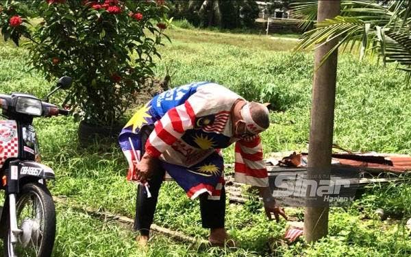 Muhammad Nasir mengutip bendera di mana-mana sahaja yang dijumpai terjatuh sebelum dibersihkan dan dikibarkan semula di rumahnya.