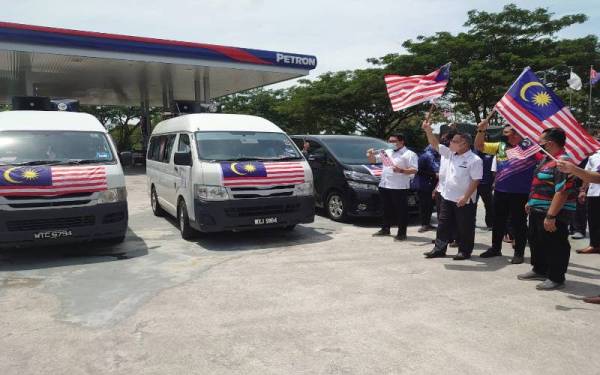 Shiau Yoon (tengah) melancarkan program Kembara Merdeka Jalur Gemilang 2021 Parlimen Tebrau di Stesen Minyak Petron, Taman Kota Masai, Pasir Gudang pada Khamis.