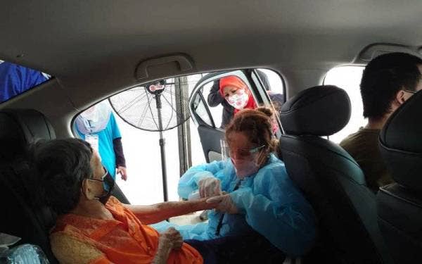 Zaiton Ismail (belakang) meninjau operasi di PPV Pandu Lalu OKU Sentral di Pusat Akuatik Arena Larkin, Johor Bahru pada Khamis.