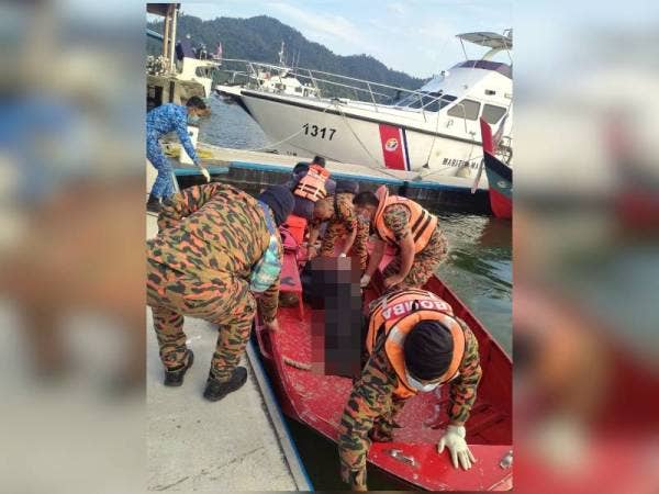 Anggota bomba membawa mayat mangsa ke Jeti Perikanan untuk diserahkan kepada pihak polis untuk tindakan selanjutnya. - Foto ihsan Bomba Perak.