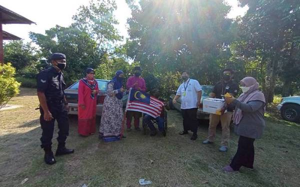 Mohd Rusli (berkerusi roda) ketika menerima sumbangan berkenaan di kediamannya pada Jumaat.