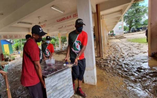 Sukarelawan yang membantu membersihkan kawasan banjir lumpur di lokasi bencana fenomena kepala air Gunung Jerai.