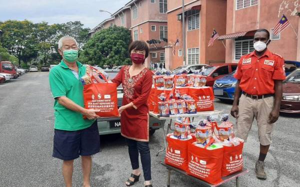 Nicole menyerahkan sumbangan bakul makanan kepada penduduk di Pangsapuri Arowana, Seremban 2 pada Ahad.