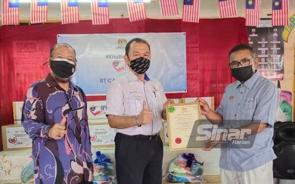Mohamed Zaizulman (kanan) menyerahkan sijil kepada Ketua (Perkhidmatan Pengguna) TNB Kedah, Wan Ishak (tengah) sambil disaksikan Pengurus RT Cares Centre Daerah Kota Setar, Abdul Kadir pada Program Agihan Kotak Makanan #Kita Bersama: RT Cares dengan kerjasama TNB Kedah di RT Cares Centre Pusat Rukun Tetangga Kampung Berjaya di sini pada Ahad.