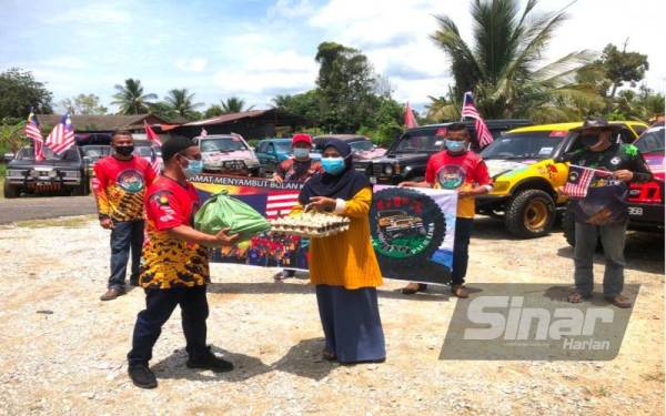 Saiful Azli (dua dari kiri) menyampaikan bantuan makanan kepada ibu tunggal anak enam, Rohani Mohamad, 54. Foto Sinar Harian