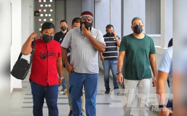 Wea Selamos (kiri), Tok Singa (tengah), Idrees (kanan) dan Mohd Eric (belakang Tok Singa) tiba di Mahkamah Majistret Kota Bharu pada Isnin.