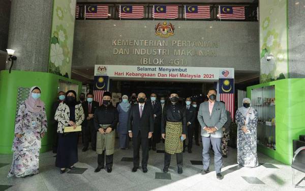 Ronald (empat dari kiri), Ahmad (kiri berbaju Melayu), Nik Muhammad Zawawi (kanan berbaju Melayu) bergambar bersama pegawai-pegawai kanan MAFI pada Isnin.